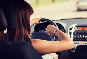 Image showing woman driving a car and looking at watch