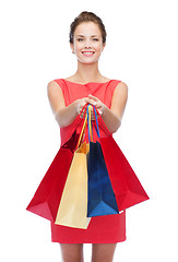 Image showing smiling elegant woman in dress with shopping bags