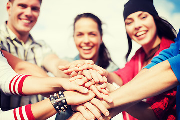 Image showing teenagers hands on top of each other outdoors