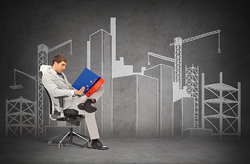 Image showing handsome businessman with folders sitting on chair