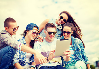 Image showing group of smiling teenagers looking at tablet pc