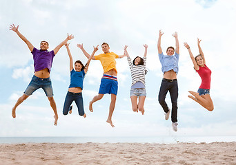 Image showing group of friends jumping on the beach