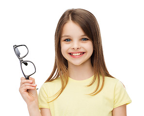 Image showing smiling cute little girl holding black eyeglasses