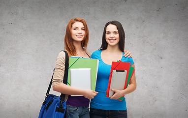 Image showing two smiling students with bag, folders and tablet