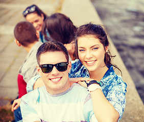 Image showing smiling teenagers in sunglasses having fun outside