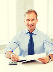 Image showing businessman with notebook and calculator