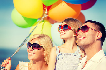 Image showing happy family with colorful balloons outdoors