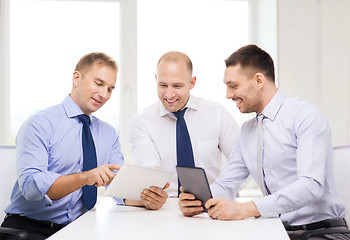 Image showing three smiling businessmen with tablet pc in office