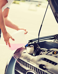 Image showing man filling windscreen water tank