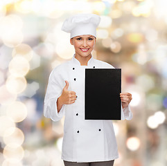 Image showing smiling female chef with black blank paper