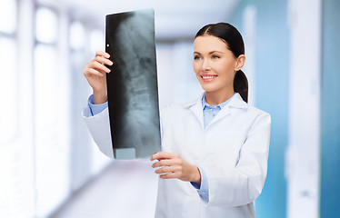 Image showing smiling female doctor looking at x-ray