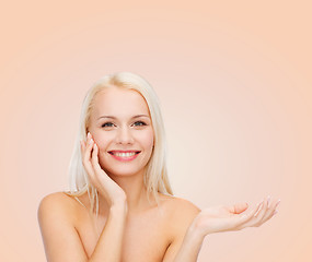 Image showing smiling woman holding imaginary lotion jar