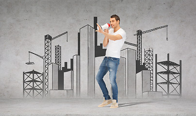 Image showing handsome man with megaphone over concrete wall