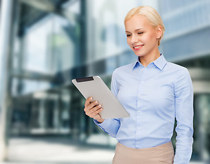 Image showing smiling woman looking at tablet pc computer