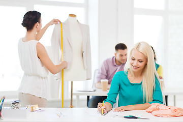 Image showing smiling fashion designers working in office