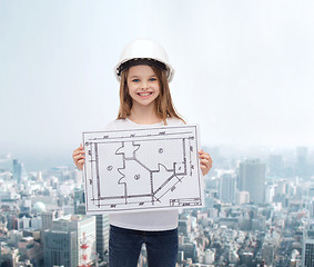 Image showing smiling little girl in helmet showing blueprint