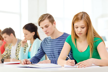 Image showing tired students with textbooks and books at school