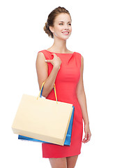 Image showing smiling elegant woman in dress with shopping bags