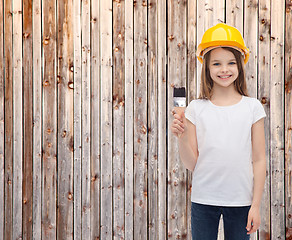 Image showing smiling little girl in helmet with paint roller