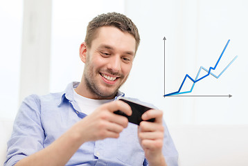 Image showing smiling man with smartphone at home