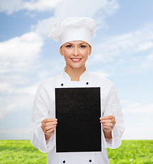 Image showing smiling female chef with black blank paper