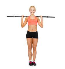 Image showing smiling sporty woman exercising with barbell