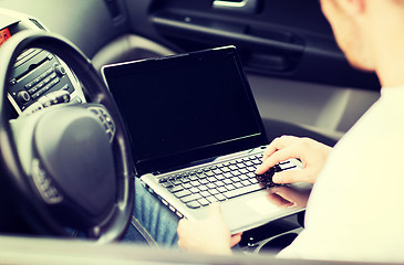 Image showing man using laptop computer in car