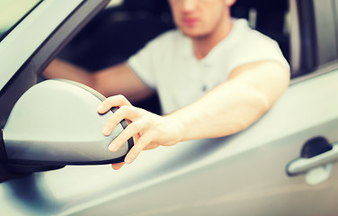 Image showing man ajusting rear view mirror