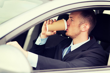 Image showing man drinking coffee while driving the car
