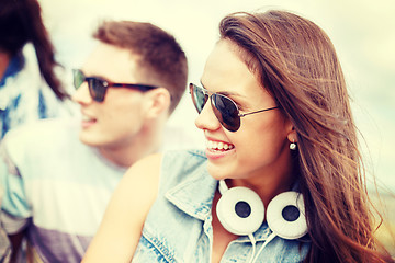 Image showing smiling teenage girl outdoors with friends