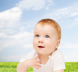 Image showing smiling baby lying on floor and looking up