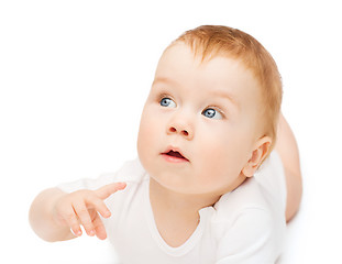 Image showing curious baby lying on floor and looking side