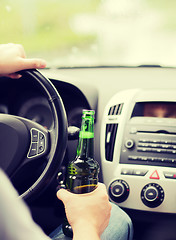 Image showing man drinking alcohol while driving the car