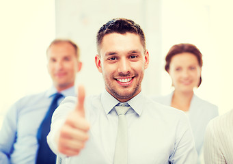 Image showing businessman in office showign thumbs up