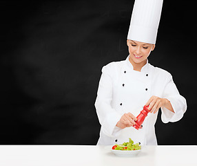 Image showing smiling female chef with preparing salad