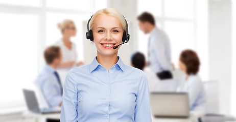 Image showing friendly female helpline operator with headphones