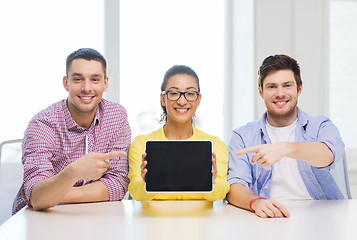 Image showing smiling colleagues showing tablet pc blank screen