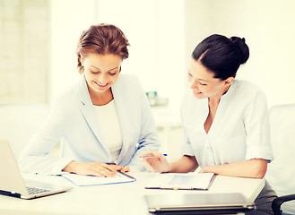 Image showing two smiling businesswomen working in office