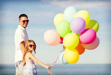 Image showing happy father and daughter with colorful balloons