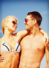 Image showing happy couple in sunglasses on the beach