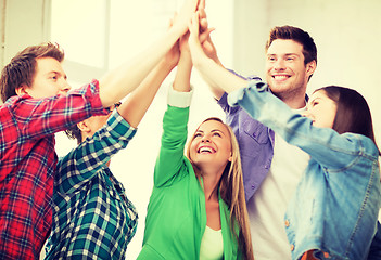 Image showing happy students giving high five at school