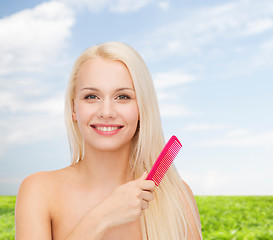 Image showing smiling woman with hair brush