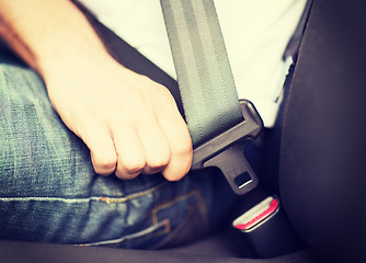 Image showing man fastening seat belt in car