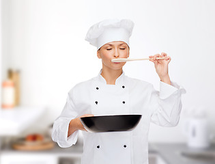 Image showing smiling female chef with pan and spoon