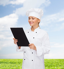 Image showing smiling female chef with black blank paper