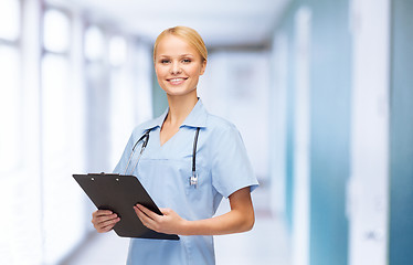 Image showing smiling female doctor or nurse with clipboard