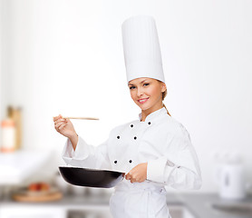 Image showing smiling female chef with pan and spoon