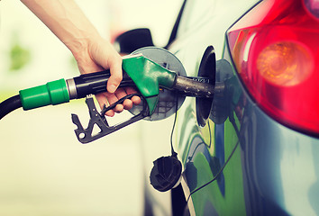 Image showing man pumping gasoline fuel in car at gas station