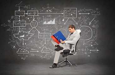 Image showing handsome businessman with folders sitting on chair