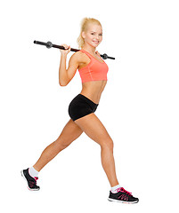 Image showing smiling sporty woman exercising with barbell